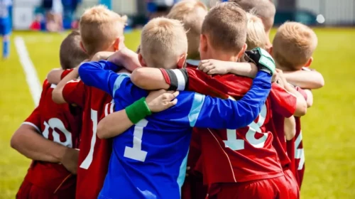 boys soccer team hugging after game
