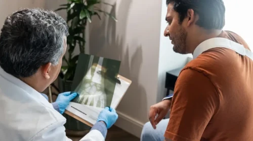 doctor and patient looking at hand x-ray