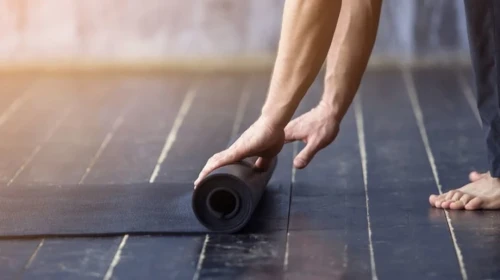 Rolling up a yoga mat after practicing yoga