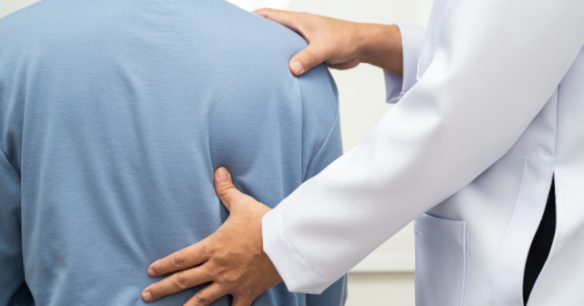 Doctor examining a patient’s neck and spine to assess nerve impingement symptoms