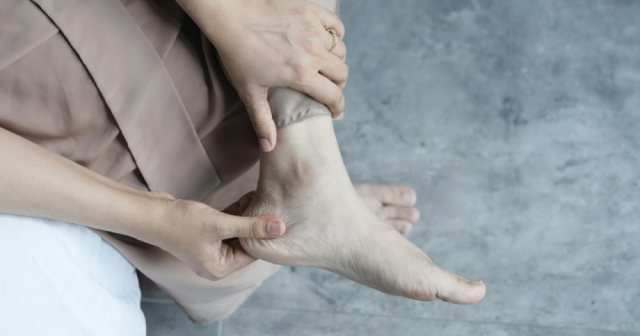 Woman rubbing ankle due to arthritis pain