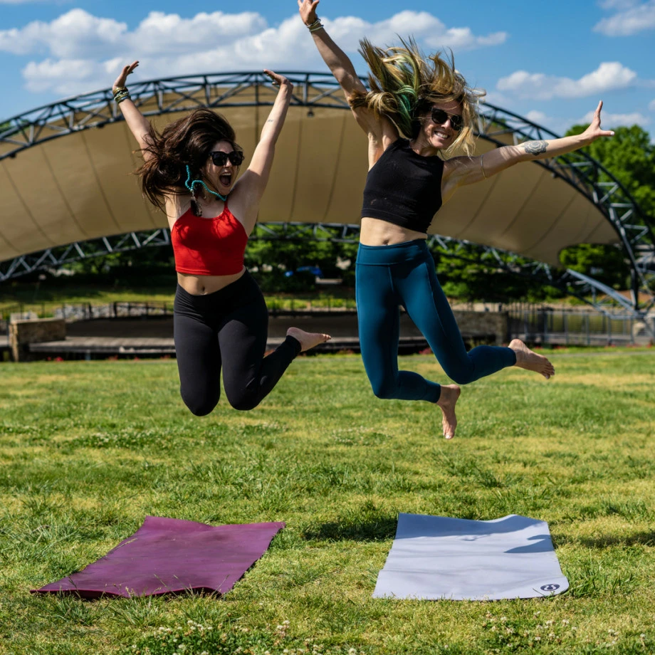 Slim beautiful women practices yoga poses on the mat beside a lake at the  outdoor park with green grass background. Yoga and life health concept with  copy and paste space. Stock Photo |