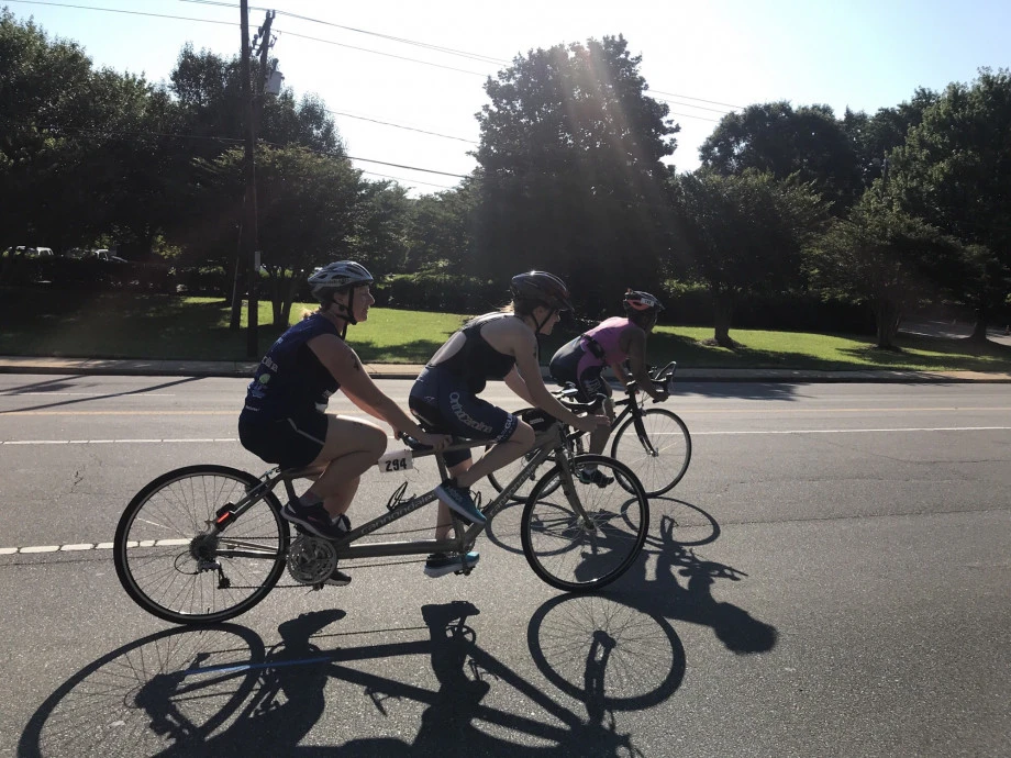 Julie competes in the cycling portion of her first triathlon alongside her guide